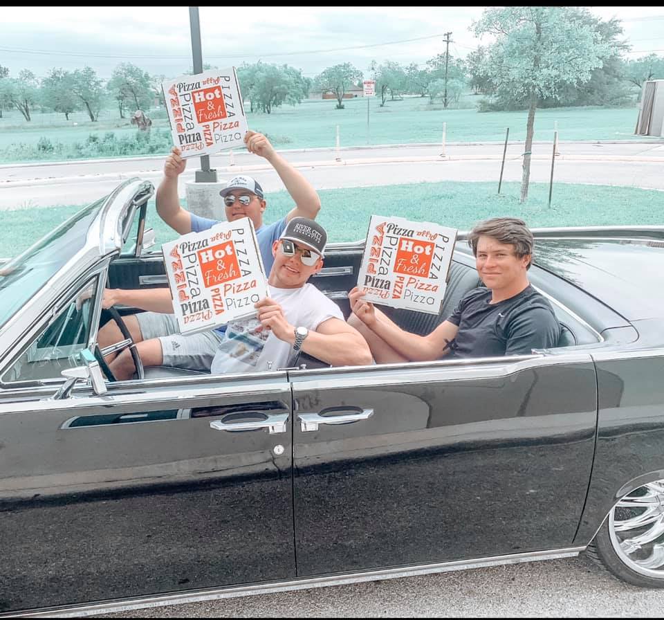 3 guys in a car holding Capparelli's pizza boxes